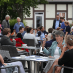 Besucher der LAG Tagung 2020 sitzend an Tischen vor der Alten Wache, Scharnhauser Park