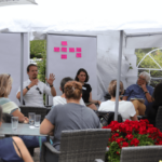 Menschen sitzen und diskutieren vor Flipcharts unter einem Pavillion bei der LAG_Tagung 2020 in Ostfildern, Scharnhauser Park