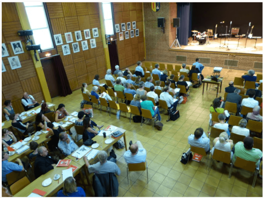 Bild zeigt Teilnehmende der LAG Tagung 2014 in einem großen Konferenzraum sitzend zur Bühne ausgerichtet.
