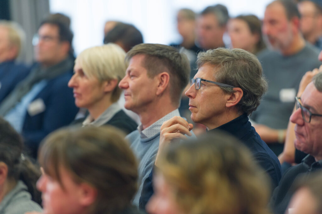 Besucher hören einer Rede zu im Rahmen der Veranstaltung Tatort Wohnen, Hospitalhof Stuttgart.